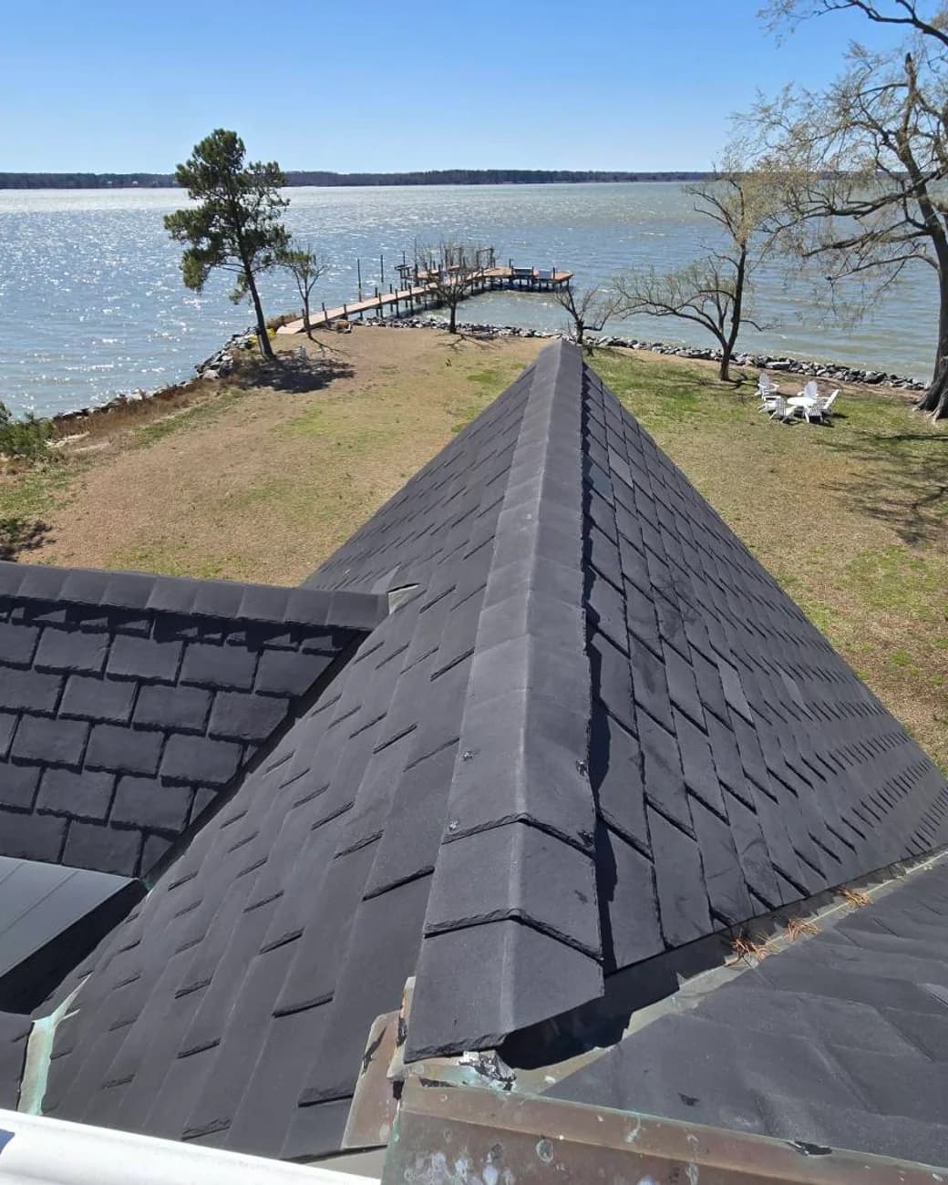 View down a roof ridge toward a private dock and open water during a Rest Easy inspection